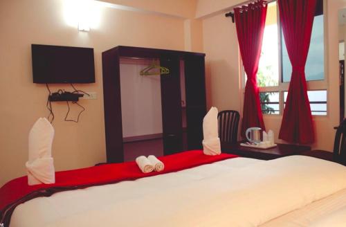 een slaapkamer met een groot bed met rode gordijnen bij Bankhim Residency (Parking available) in Gangtok