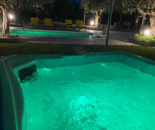 a hot tub in a yard at night at Olive Sense Villa with jacuzzi and sauna in Afantou