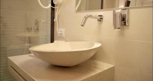 a bathroom with a bowl sink and a shower at La Maison in Taranto