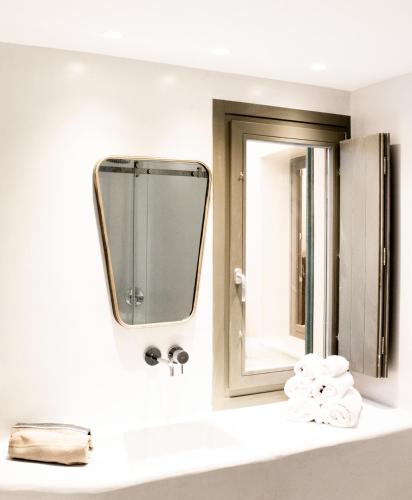 a bathroom with a mirror and a sink with towels at Aregou Villas in Imerovigli