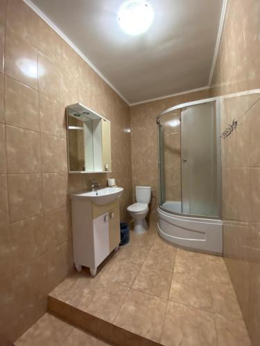 uma casa de banho com um lavatório, um chuveiro e um WC. em Людмила em Chornomorsk