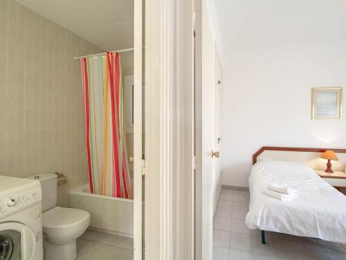 a bathroom with a toilet and a shower curtain at PORT III Sistach Rentals in L'Estartit
