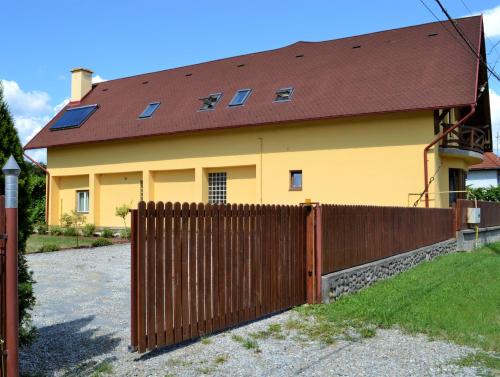 a yellow house with a fence in front of it at Rozsi Mama in Sovata