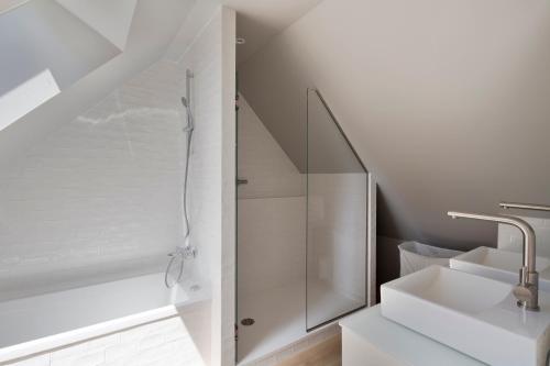 une salle de bain blanche avec une douche et un lavabo dans l'établissement Villa Epicure by Cocoonr - Belle maison proche de la plage, à Saint-Lunaire