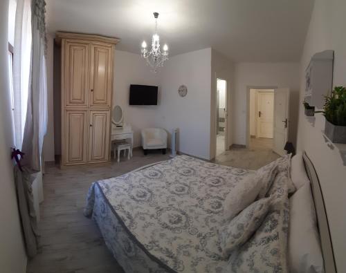 een slaapkamer met een bed en een kroonluchter bij Corte degli Angeli in Marina di Grosseto