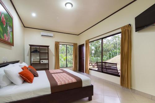 a bedroom with a bed and a large window at Arenal Volcano Inn in Fortuna