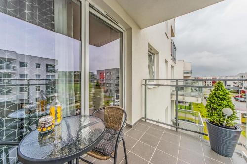 a table and chairs on a balcony with a view of a city at Apartament Lemon in Pruszcz Gdański
