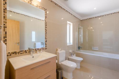a bathroom with a sink and a toilet and a tub at Boavista Resort - Casa Belinda in Lagos