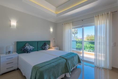 a bedroom with a bed and a large window at Boavista Resort - Casa Belinda in Lagos