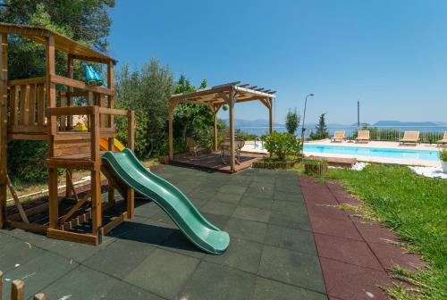 a playground with a slide and a gazebo next to a pool at Violitzis Villas in Neokhórion