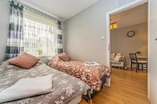two beds in a room with a window at Apartament Lemon in Pruszcz Gdański