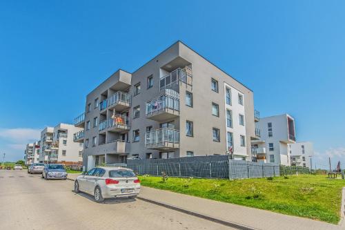 a apartment building with cars parked in front of it at Apartament Lemon in Pruszcz Gdański