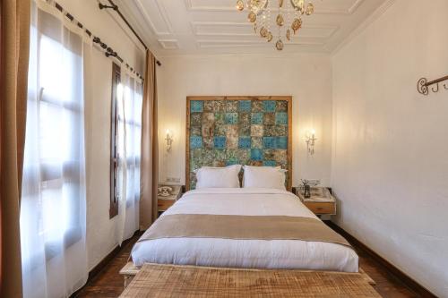 a bedroom with a large bed and a chandelier at Trilye Bay C Konak in Bursa