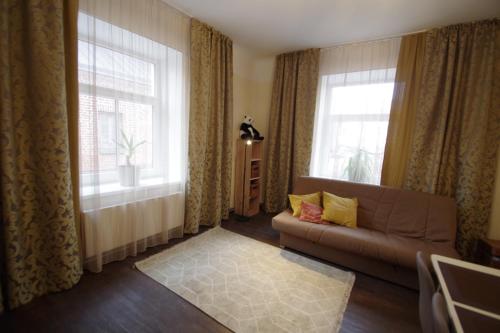 a living room with a couch and two windows at Panda House - Luxury in Old Town in Tartu