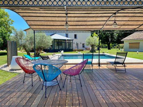 um pátio com uma mesa e cadeiras e uma piscina em Ô gré des sens em Coufouleux