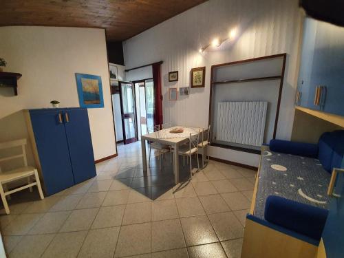 Habitación con mesa y cocina con armarios azules. en Agriturismo Il Burlino Apartments, en Lerma