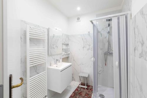 baño blanco con ducha y lavamanos en Al Pozzo Bianco, en Orvieto