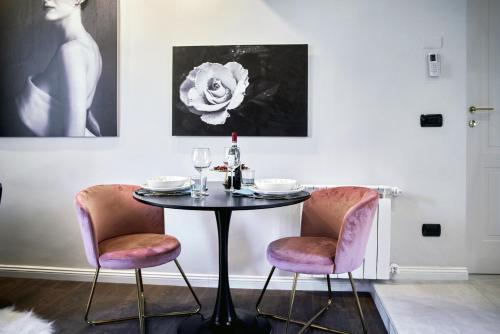 a dining room with a table and two chairs at S A R O N A ChicLife Design Apt next to the Museum in Bergamo