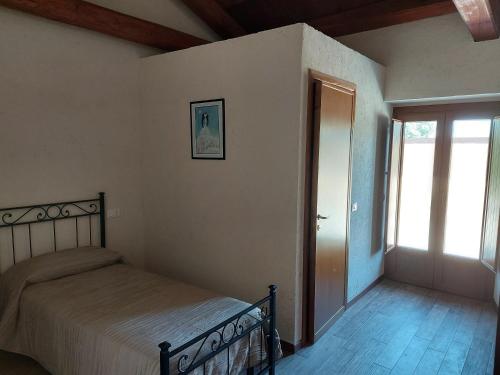 a bedroom with a bed and an open door at Il pozzo dei desideri in Castelnuovo