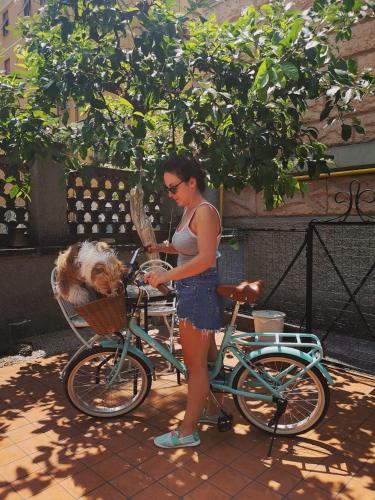 a woman standing next to a bike with a dog in a basket at Relais Villa Fiorelli in Rome