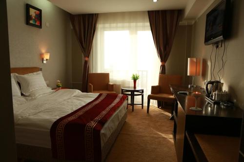 a hotel room with a bed and a desk and a window at Park Hotel in Ulaanbaatar