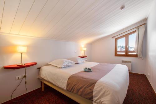 1 dormitorio con 1 cama con 2 lámparas y una ventana en Résidence Pierre & Vacances Le Mont Soleil en La Plagne