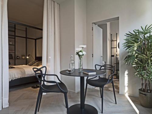 ein Esszimmer mit einem Tisch, Stühlen und einem Bett in der Unterkunft Dimora Arco di Mezzo in Battaglia Terme