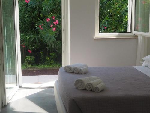 a bedroom with a bed with rolled towels on it at Fair Garden in Bardolino