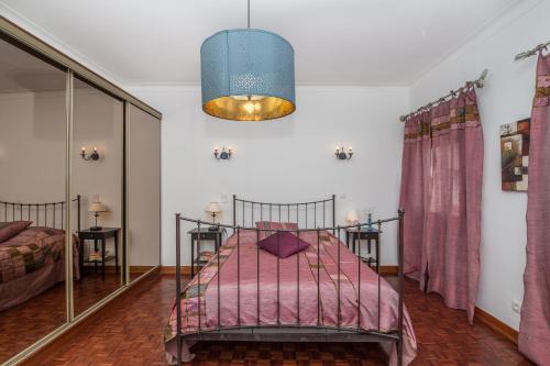 1 dormitorio con 1 cama con manta rosa en Casa dos Pais en Silves