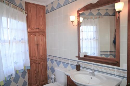 a bathroom with a sink and a toilet and a mirror at Casa Nine con piscina Vacacional La Palma in Breña Baja