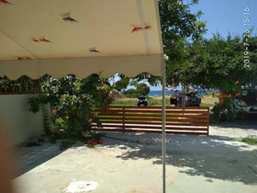 a park with a wooden bench and an umbrella at Kitesurf Paradise Studios in Theologos