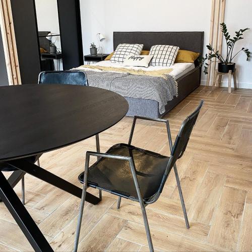 a table and chairs in a room with a bed at Apartament Happy Loft MF in Giżycko