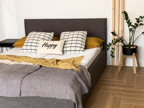 a bedroom with a bed with a happy pillow on it at Apartament Happy Loft MF in Giżycko