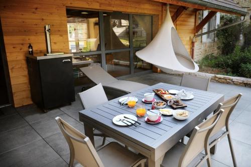 - une table bleue avec de la nourriture sur la terrasse dans l'établissement Maison d'hôtes & SPA La Scierie, à Salins-les-Bains