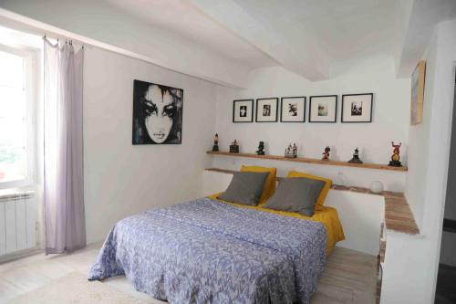 sypialnia z łóżkiem z niebieską kołdrą w obiekcie Appartement dans le ciel w mieście Tourtour