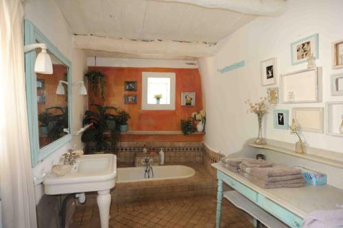 uma casa de banho com um lavatório e uma banheira em Appartement dans le ciel em Tourtour