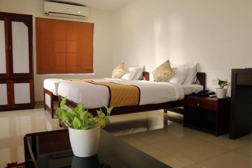 a bedroom with a bed with white sheets and pillows at The Rubis in Kottakkal