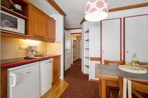 a kitchen with a sink, stove, microwave and refrigerator at Résidence Pierre & Vacances Le Mont Soleil in La Plagne