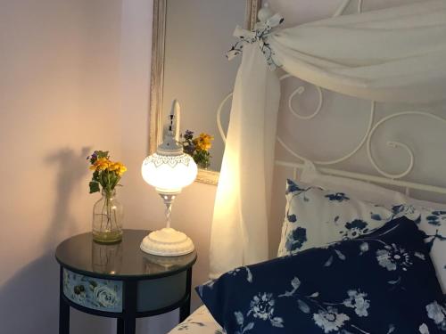 - une chambre avec un lit et une table avec une lampe dans l'établissement Sunflower Guest House Bulgaria, à Stefan Stambolovo