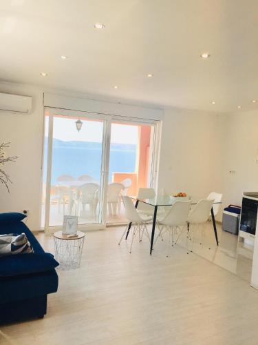 a living room with a table and chairs and the ocean at Apartments Juraković in Živogošće