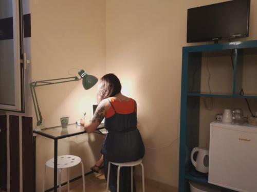 a woman standing at a table with a lamp at Relais Villa Fiorelli in Rome
