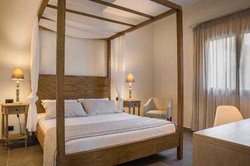 ein Schlafzimmer mit einem Himmelbett und einem Schreibtisch in der Unterkunft ASTRA Village Resort in Svoronata