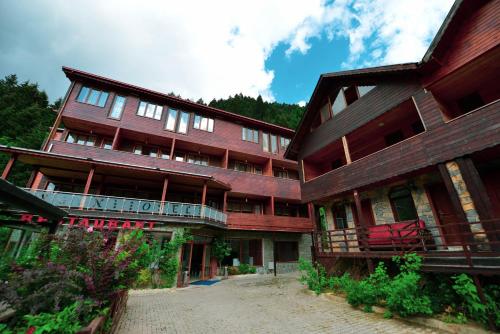 ウズンギョルにあるAygün Suites Hotel&Bungalow UZUNGÖLの大きな木造の建物で、バルコニーが正面にあります。