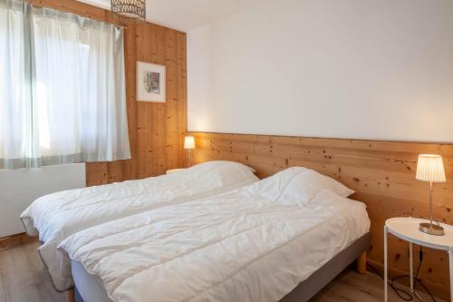 ein Schlafzimmer mit einem weißen Bett und einem Fenster in der Unterkunft BERGERS 1 in Morzine
