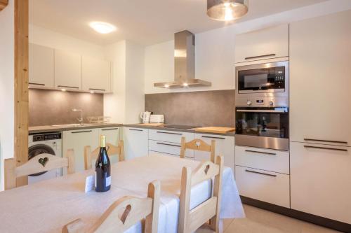 - une cuisine avec une table et une bouteille de vin dans l'établissement BERGERS 1, à Morzine