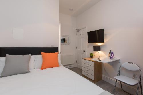 a bedroom with a bed and a desk and a chair at Townhouse PLUS @ 130 West Street Crewe in Crewe