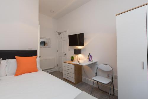 a bedroom with a bed and a desk and a chair at Townhouse PLUS @ 130 West Street Crewe in Crewe