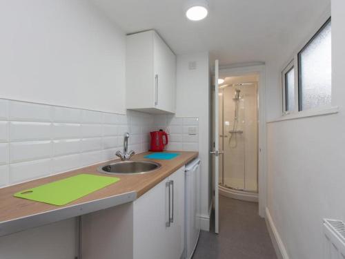 uma cozinha com um lavatório e uma bancada em Townhouse @ 166 Ruskin Road Crewe em Crewe