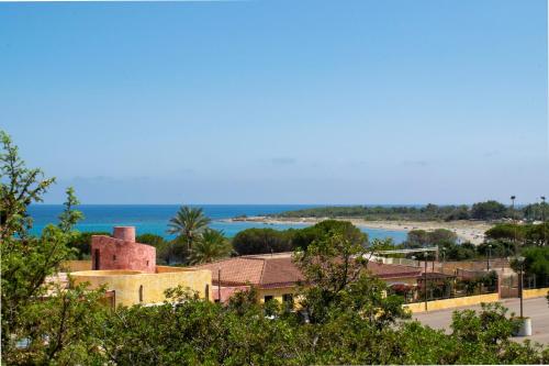 een uitzicht op een strand met een gebouw en de oceaan bij Casa Deidda in Villaputzu