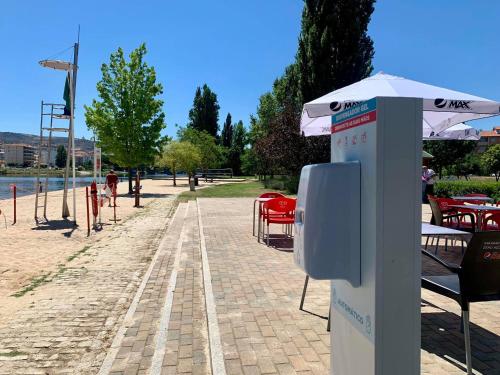 a phone booth with an umbrella and tables and chairs at Apartamento Trav. Santa Luzia in Mirandela